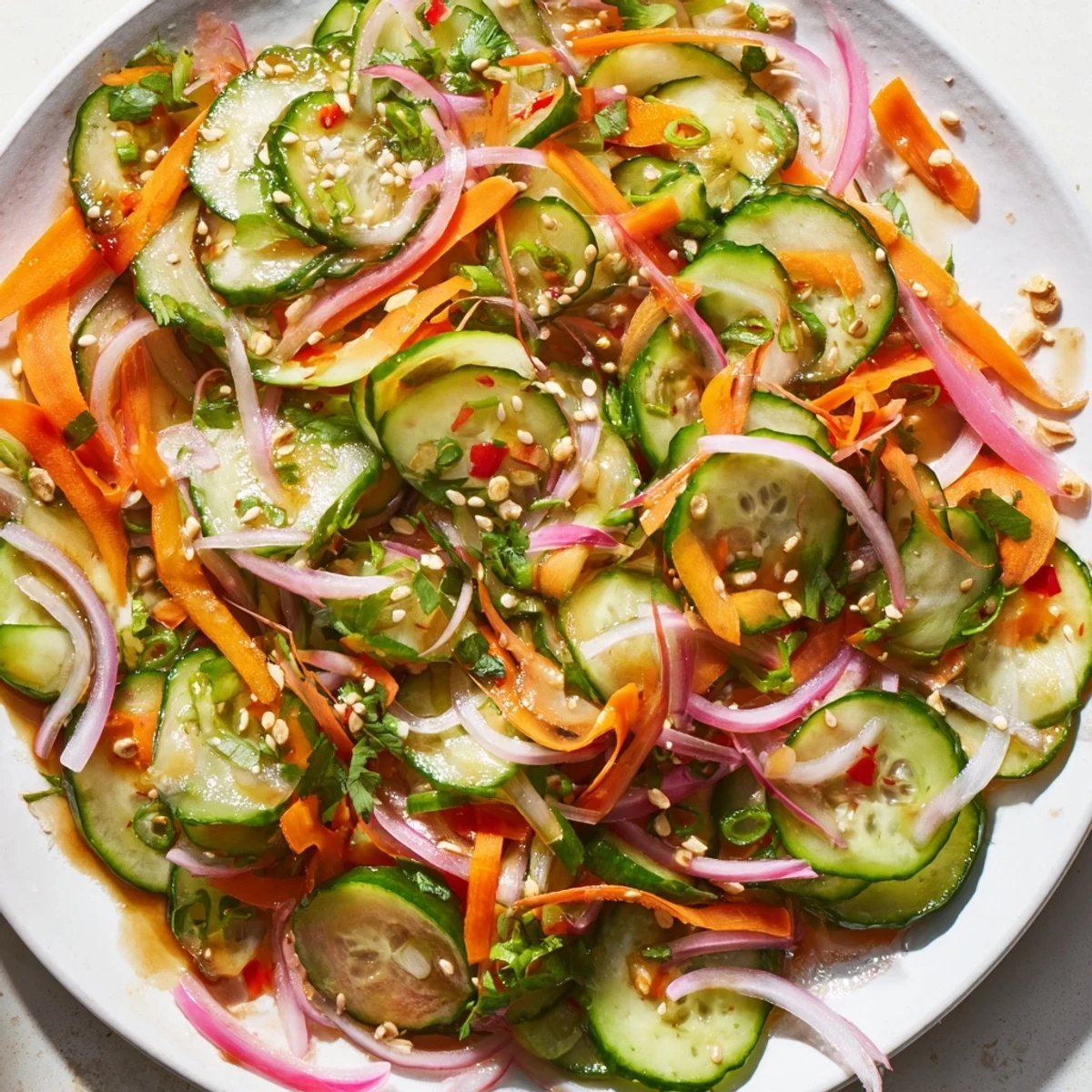 Crisp cucumber salad remix drizzled with sesame oil and vibrant garnishes.