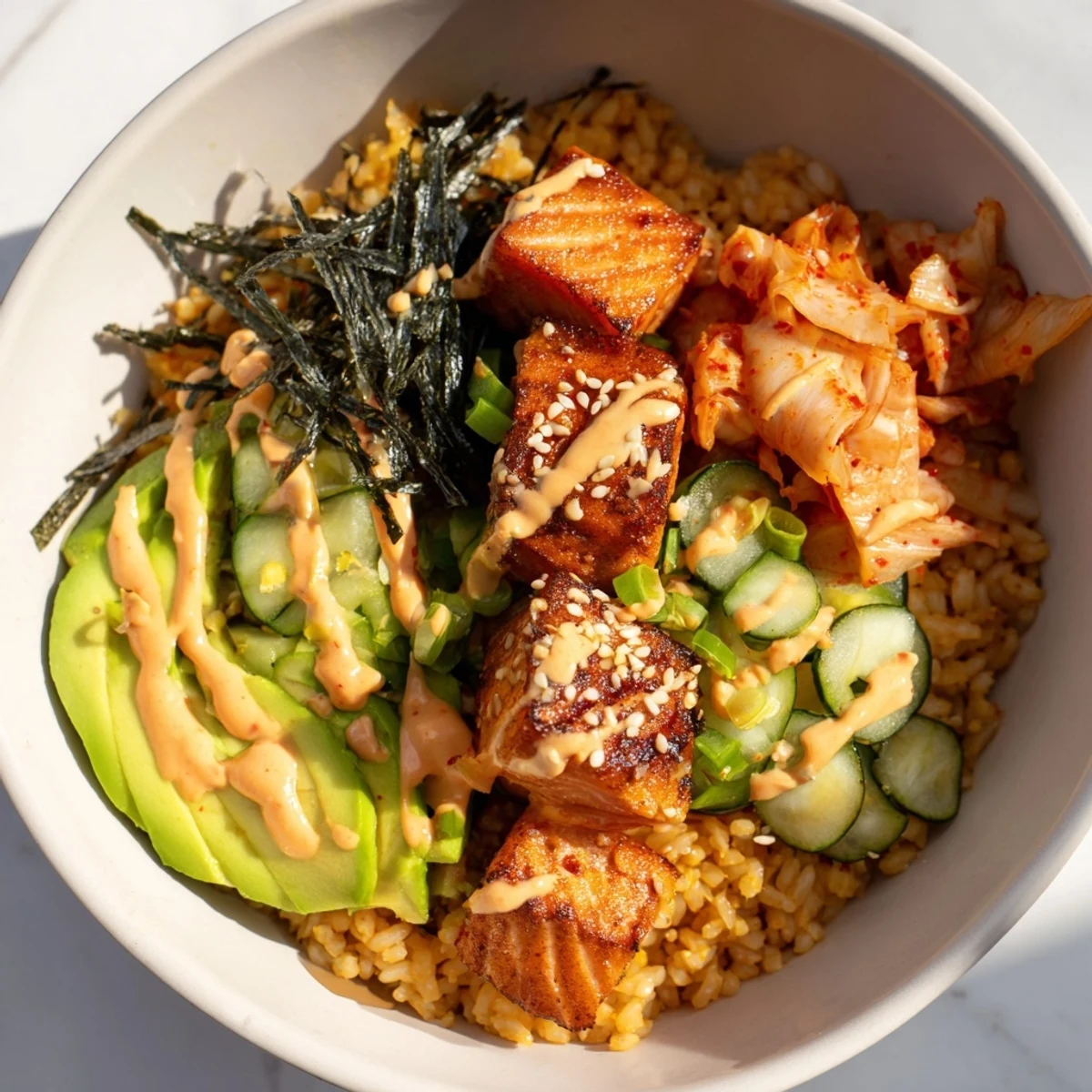 Delicious salmon rice bowl featuring fluffy rice, spicy mayo, and tangy kimchi accents.