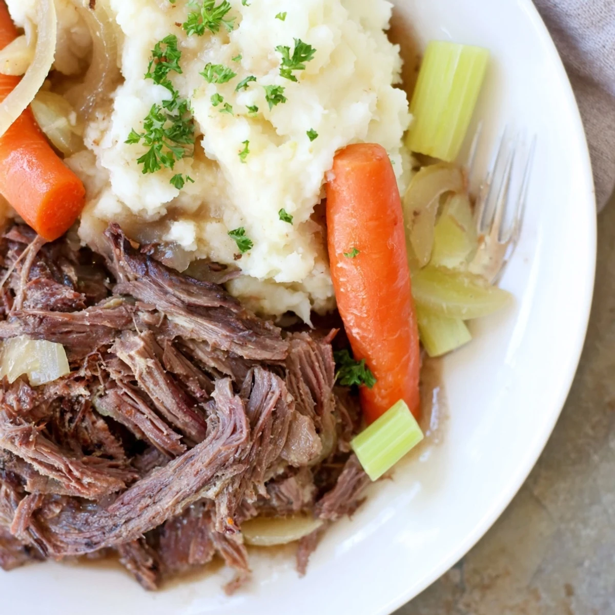 Tender slow cooker pot roast served over creamy mashed potatoes with rich gravy.  