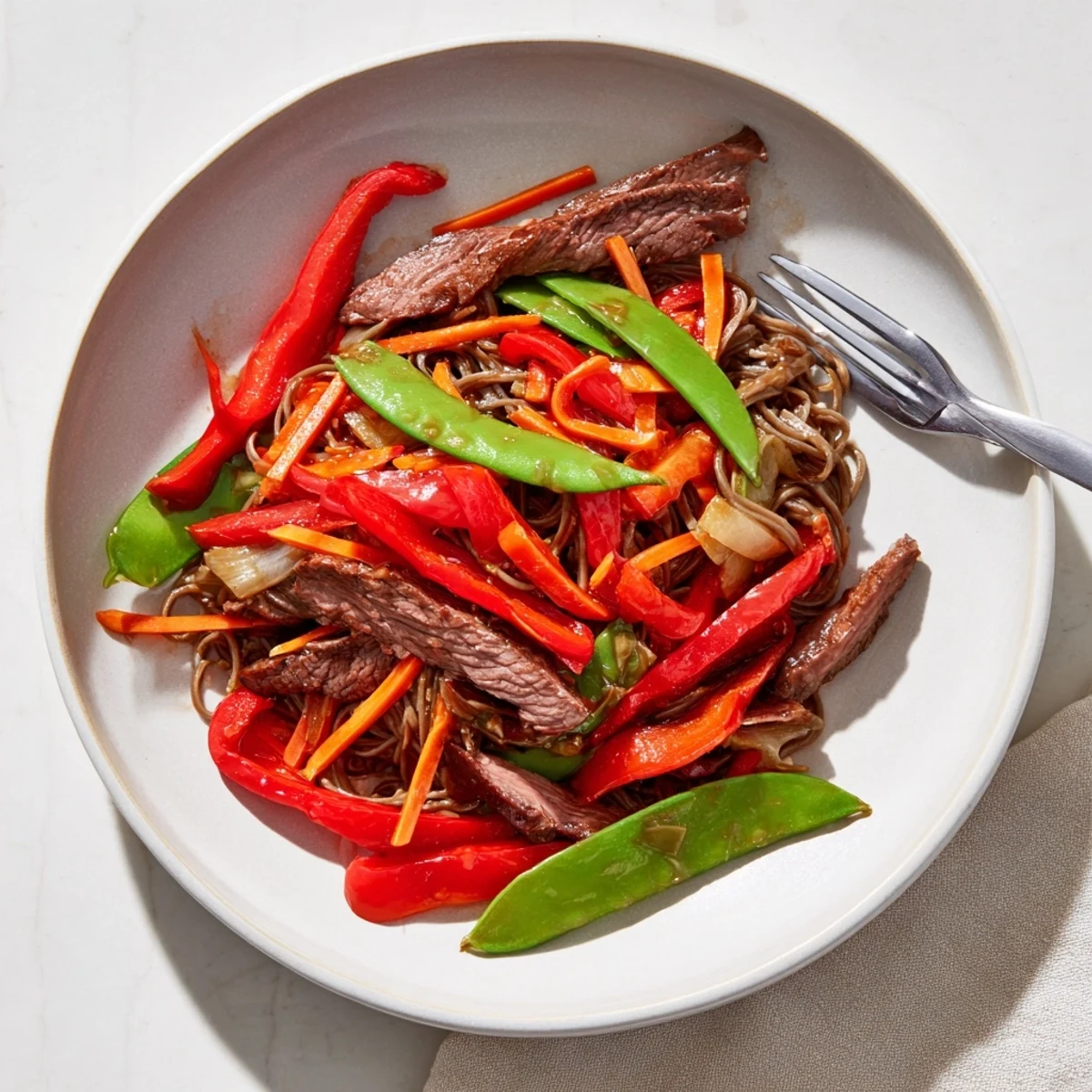 Steaming Teriyaki Beef & Noodle Bowl with glistening sauce, colorful vegetables, and tender beef arranged on noodles.