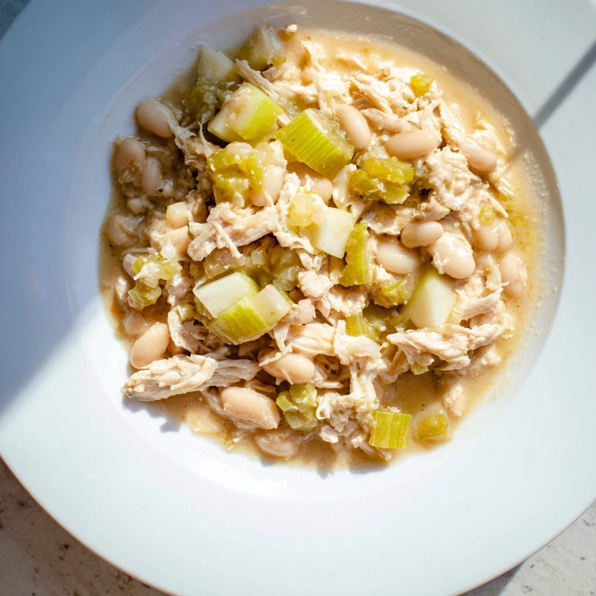 Warm, creamy 35-Minute White Cheddar Apple Chicken Chili, beautifully topped with melted cheddar cheese ready to serve.