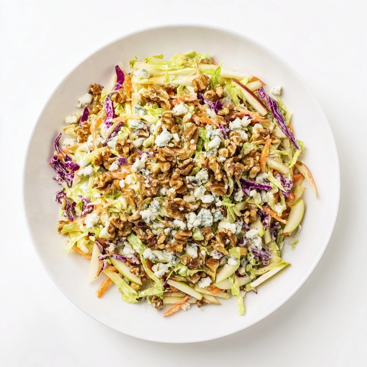 A refreshing bowl of Crunchy Apple & Walnut Slaw, showcasing crisp apple slices and crumbled blue cheese.