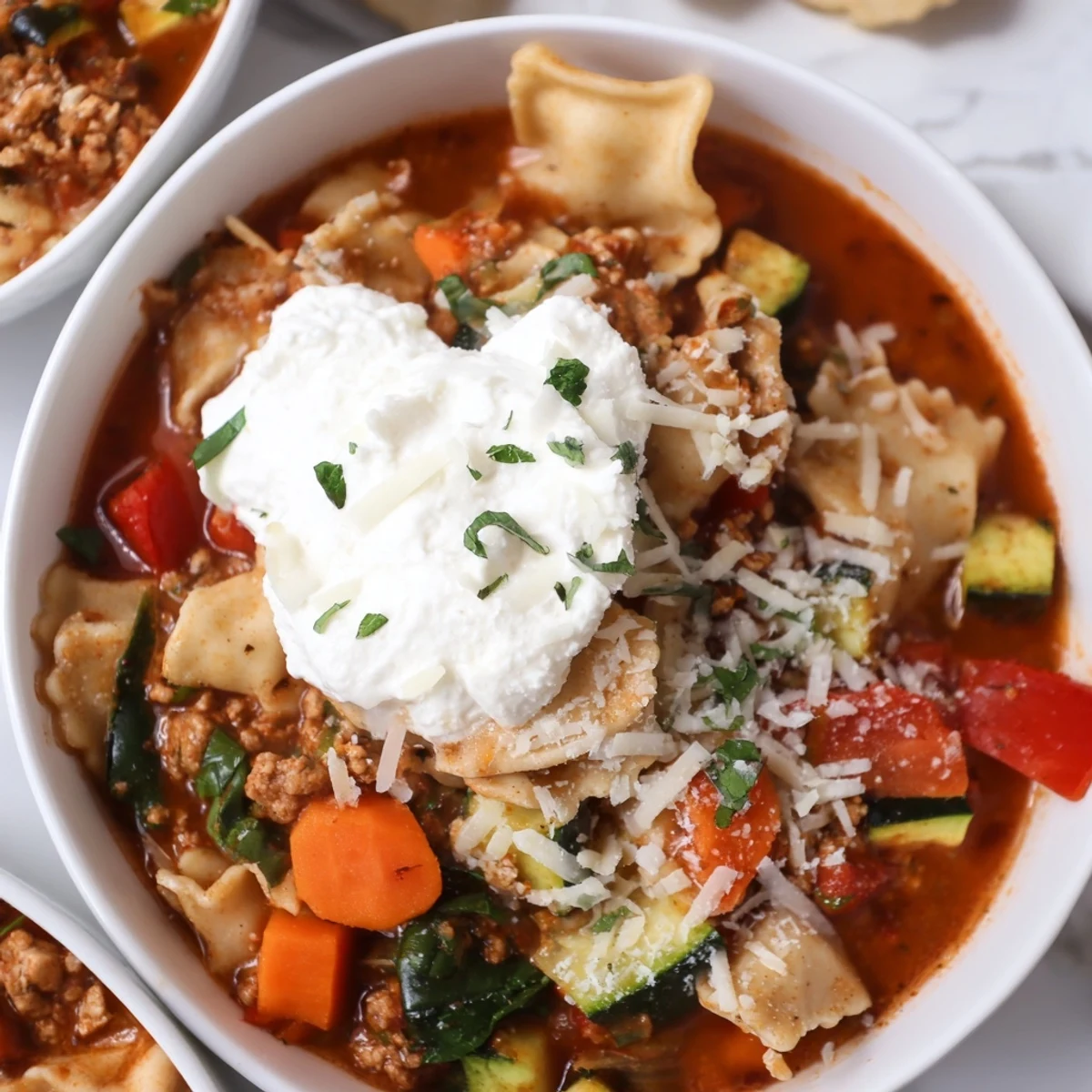 Healthy Lasagna Soup, garnished with vibrant cheeses and fresh herbs, a comforting bowl.