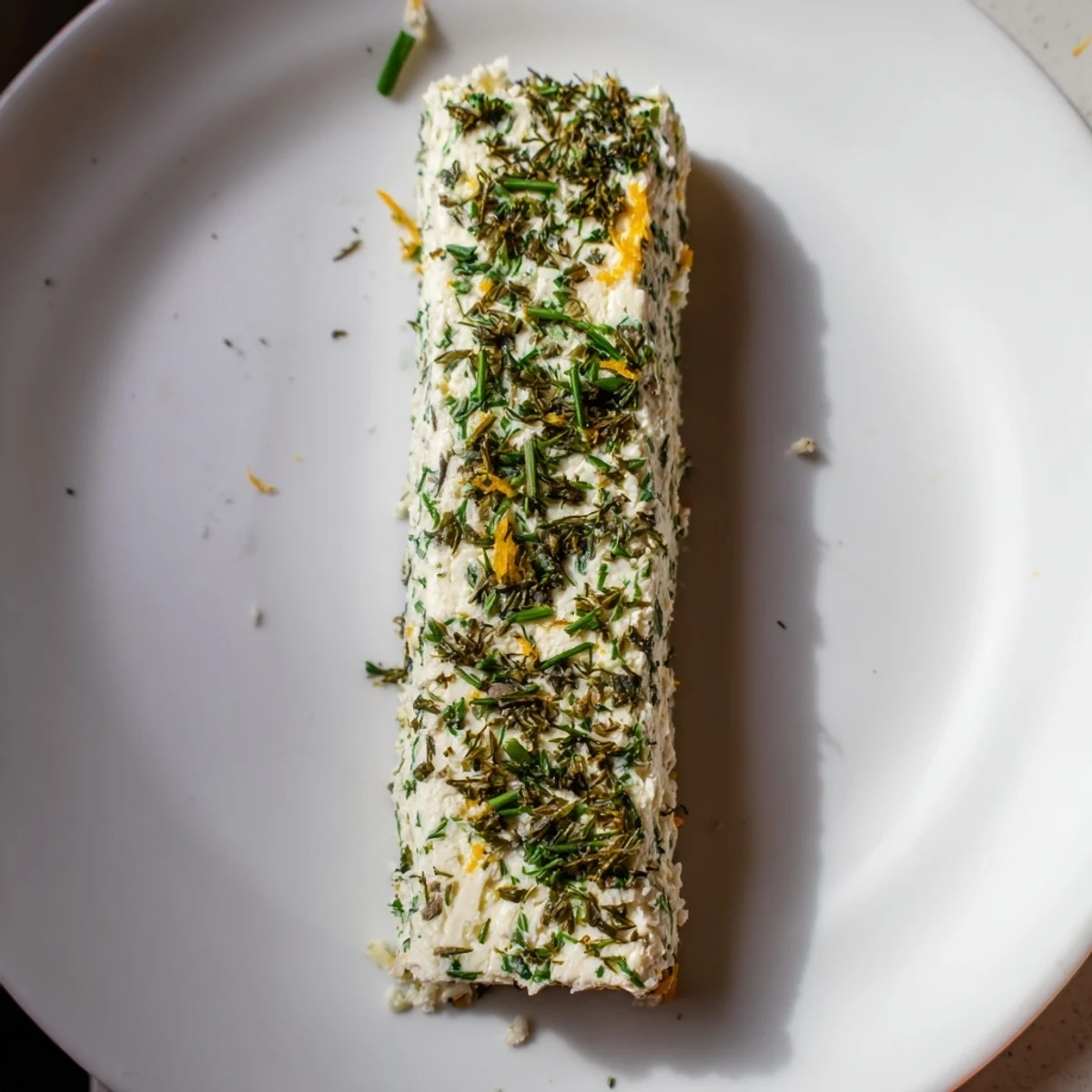A close-up of a creamy Herb-Coated Cheese Log, perfect for an elegant appetizer table.