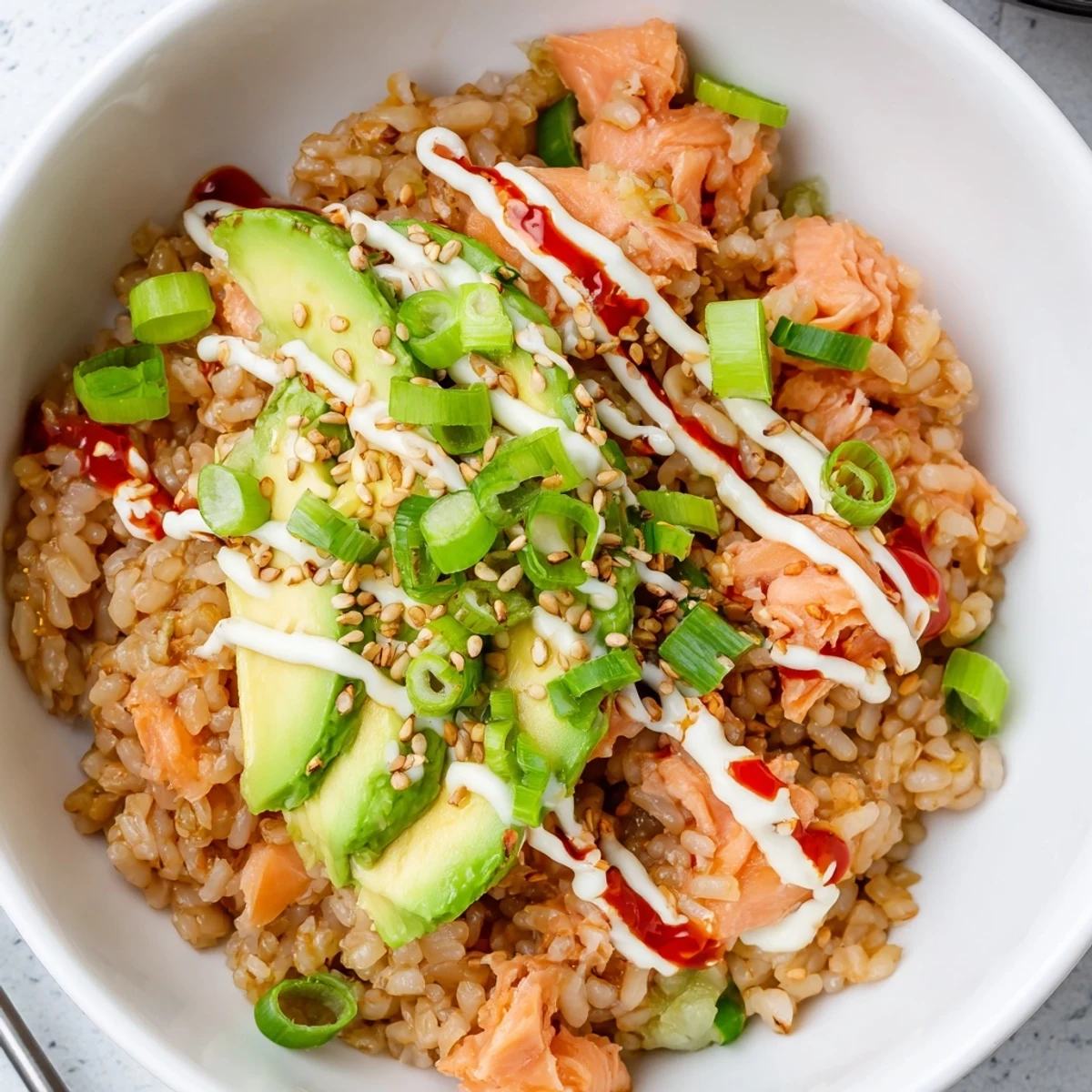 Enjoy the savory look of an Emily Mariko Salmon Rice Bowl with toasted sesame seeds and delicious seaweed.