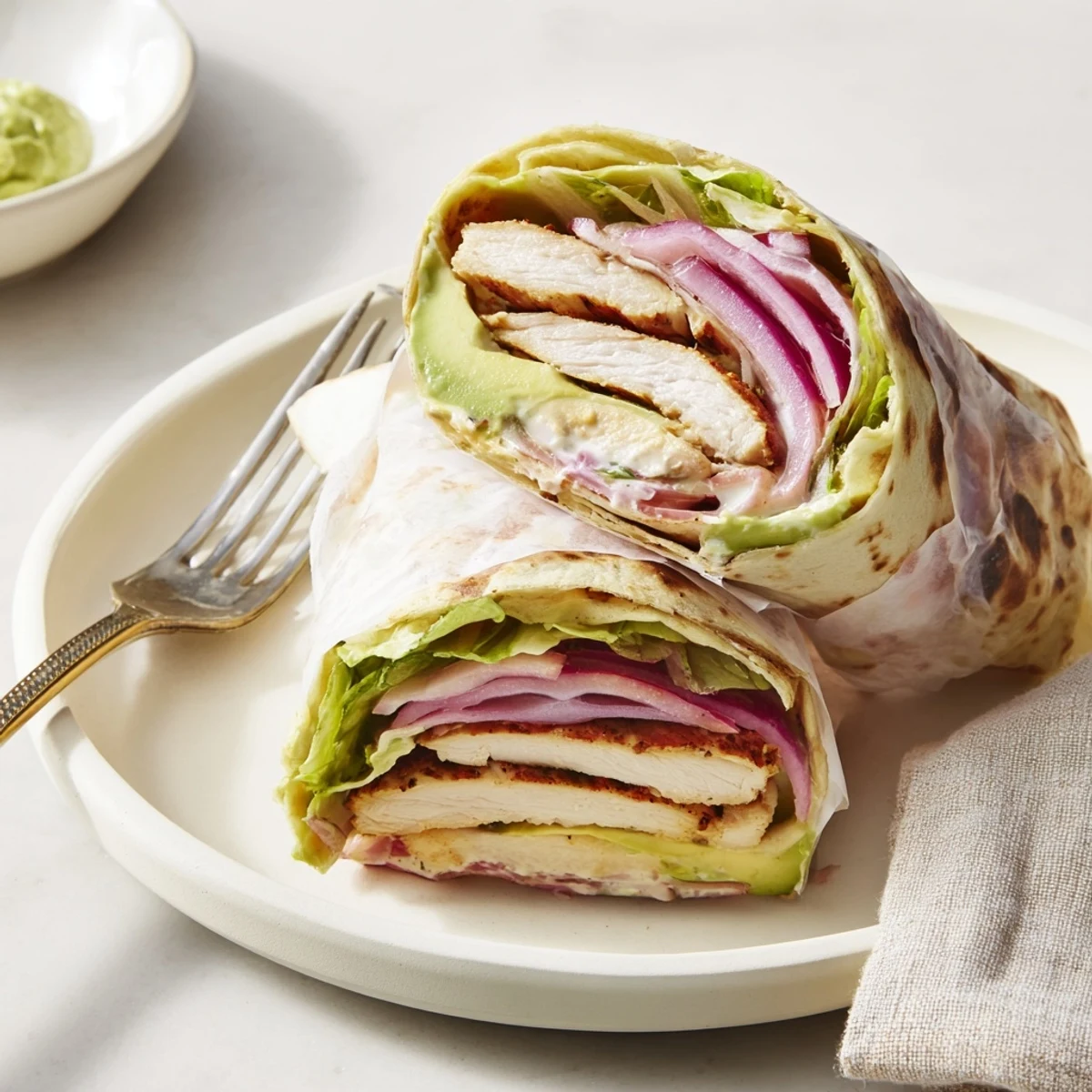 Grilled Smoky Chipotle Chicken Wrap slices revealing juicy marinated chicken and creamy avocado nestled in a soft tortilla.  
