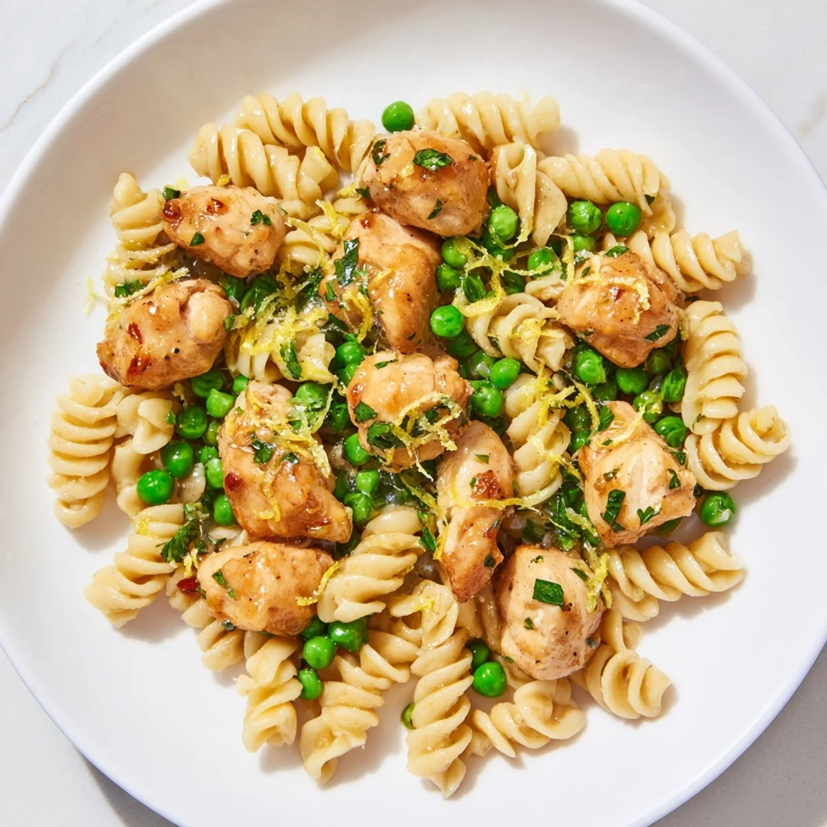Family-friendly Garlic Butter Chicken & Pea Pasta served hot, featuring juicy chicken, sweet peas, and pasta in a glossy buttery sauce.