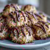 A close-up shows Vegan Coconut Macaroons with Dark Chocolate Drizzle, the glossy dark chocolate setting against fluffy coconut.