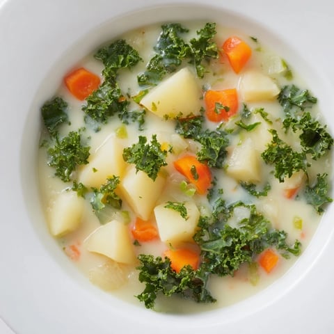 Steaming bowl of Vegetarian Potato-Kale Soup, brimming with tender potatoes and vibrant green kale.