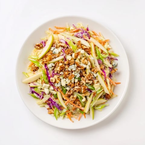 Vibrant Crunchy Apple & Walnut Slaw with Blue Cheese, ready to serve with creamy crumbles and toasted walnuts.