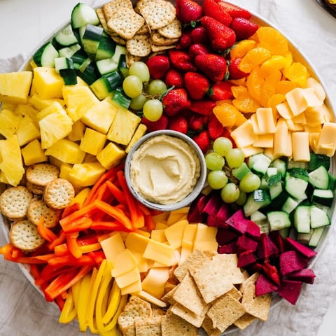 Sunshine Snack Tray overflowing with bright, fresh fruits, vegetables, cheeses, and dips, a colorful appetizer.