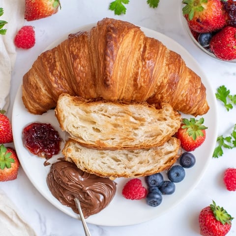 Cozy Fireplace Croissant Board with warm, flaky croissants, berries, and cheeses, ready to enjoy.