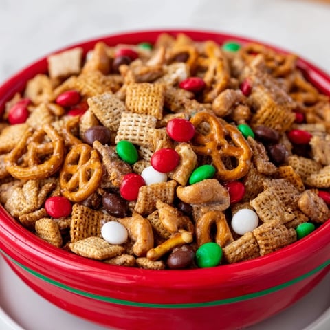 Festive holiday mix bursting with crunchy Chex, pretzels, and colorful candies; ready to eat.