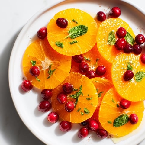 Vibrant photo: Winter fruit salad with orange slices, cranberries, and a honey-lime dressing.