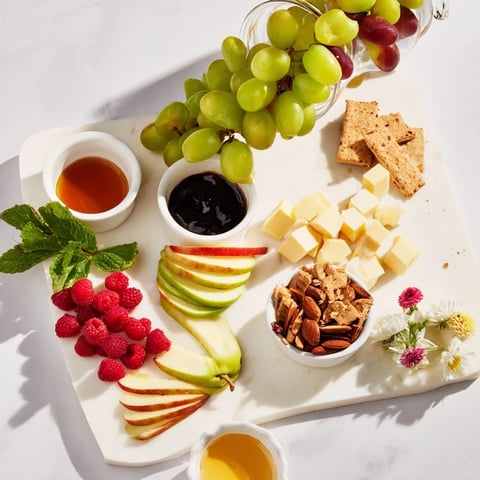 Champagne Waterfall Board overflowing with grapes, cheeses, and crackers; a delicious party appetizer.