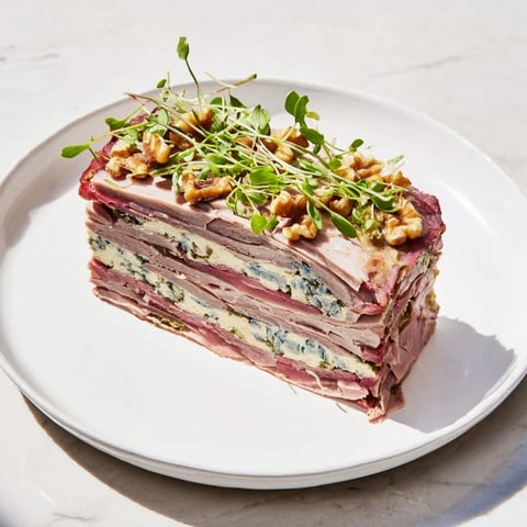 Visually stunning Grand Canyon Rim terrine, showcasing layered meats and a vibrant blue cheese river.