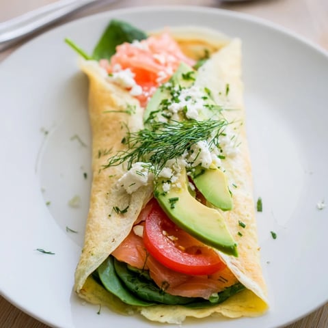 Blender-Egg Crepe Wrap, thin and golden, filled with fresh spinach and savory smoked salmon for breakfast.