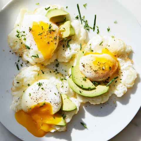 Fluffy baked Cloud Bread Breakfast Clouds, topped with creamy avocado and perfectly poached eggs, ready to eat.