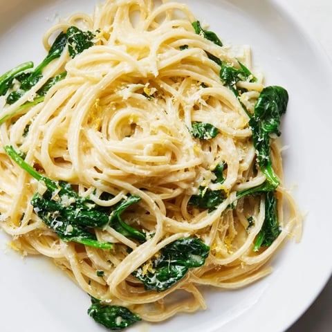 Creamy Lemon Spinach Spaghetti served in a shallow bowl with vibrant green spinach and grated Parmesan garnish.  