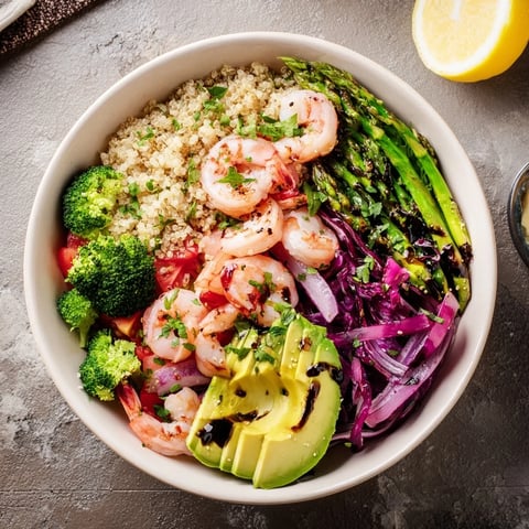 This vibrant Detox Buddha Bowl with Shrimp and Quinoa features succulent pink shrimp and fluffy grains piled high with crisp broccoli and bright red cabbage.