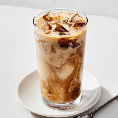A refreshing Tahini Iced Coffee topped with creamy plant-based milk and ice.  
