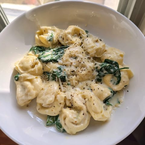 Enjoy savory Creamy Spinach Alfredo Tortellini with perfectly cooked cheese tortellini coated in a flavorful white sauce.