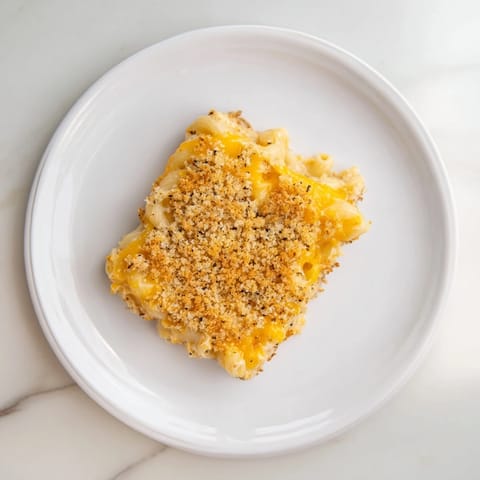A close-up of cheesy, steaming Mac & Cheese with Evaporated Milk, freshly baked, oozing with delicious cheese.
