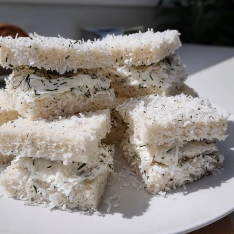 Freshly made bite-sized Snowball Tea Sandwiches with creamy filling and coconut exterior, delicious!