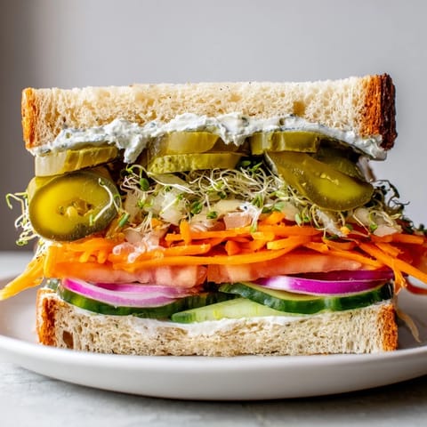 A close-up of a delightful crunchy dill pickle sandwich, juicy, with pickles spilling out.