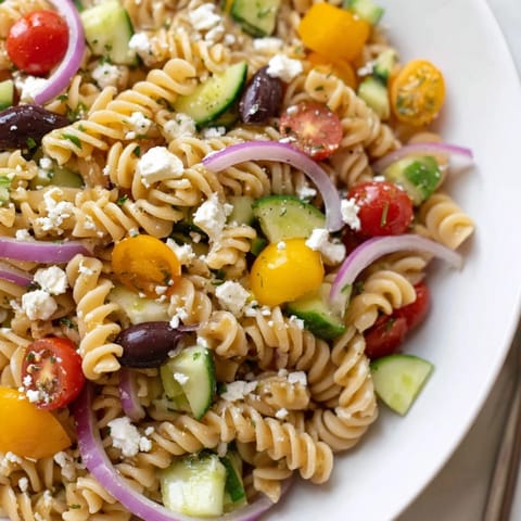 Freshly tossed lemon pasta salad with bright tomatoes, ready for a delicious picnic or meal.