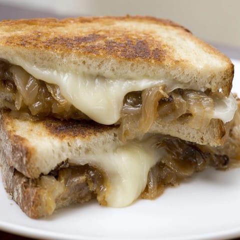 Golden Caramelized Onion Grilled Cheese on sourdough, showing oozing sharp cheddar and jammy onions.