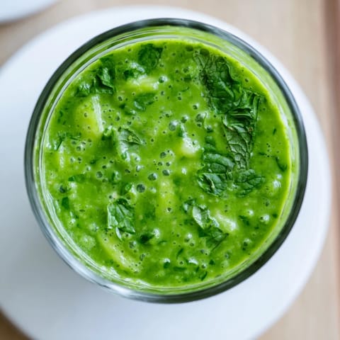 Vibrant green smoothie in a tall glass, packed with leafy greens, apple, and chia seeds for a nutritious boost.