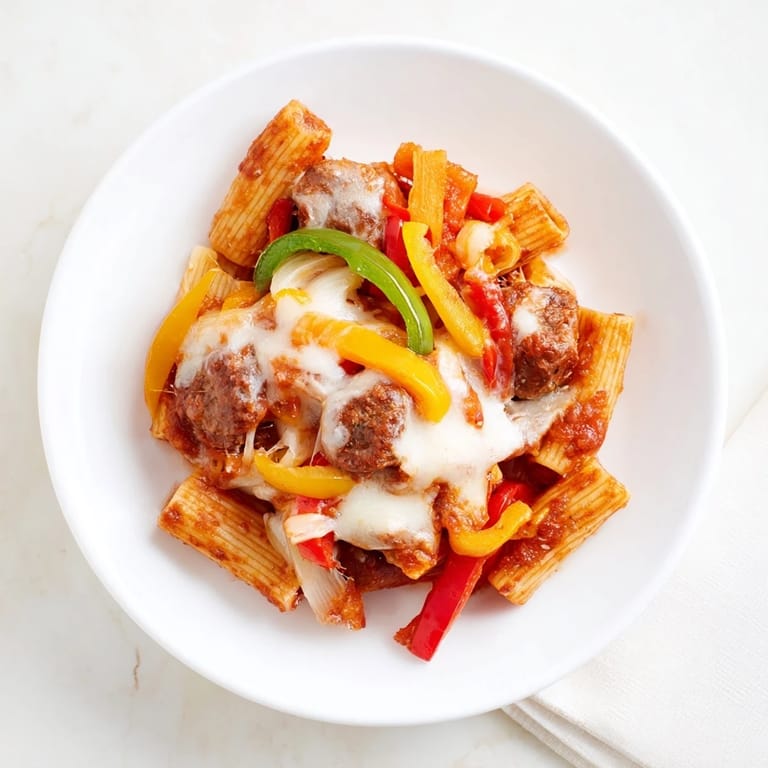 Sausage and pepper-filled Baked Rigatoni, a comforting Italian-American meal with golden, crisp cheese topping.