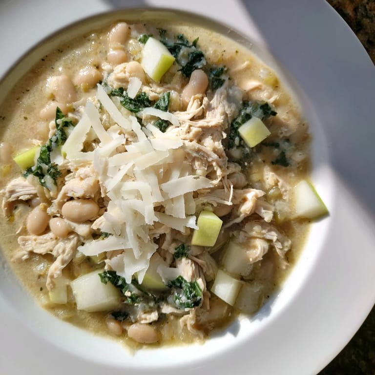 A steaming bowl of 35-Minute White Cheddar Apple Chicken Chili, perfect for a cozy fall evening meal.