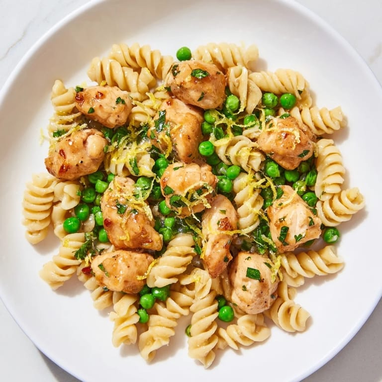 Family-friendly Garlic Butter Chicken & Pea Pasta served hot, featuring juicy chicken, sweet peas, and pasta in a glossy buttery sauce.