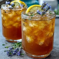 A refreshing lavender honey lemonade pitcher, fragrant and floral, served with lemon slices and fresh lavender sprigs.