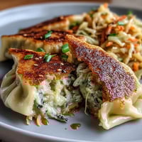 Crispy golden dumplings filled with seasoned cabbage, served hot with ginger soy dipping sauce.  